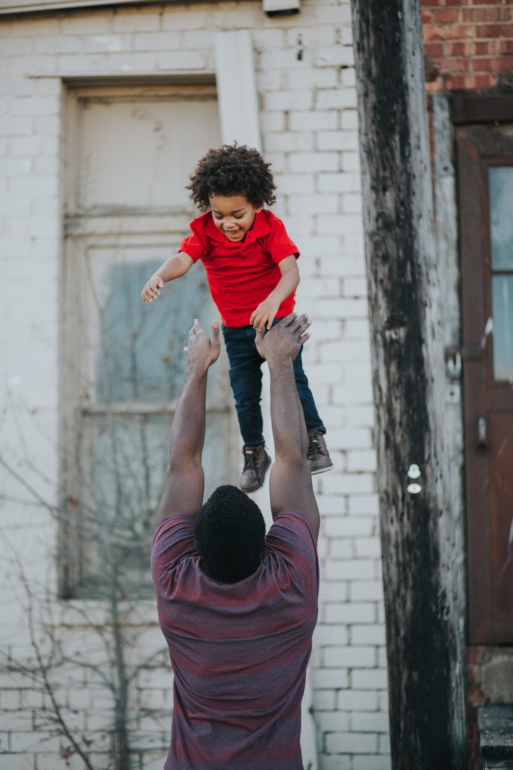 A father tossing his son up in the air.