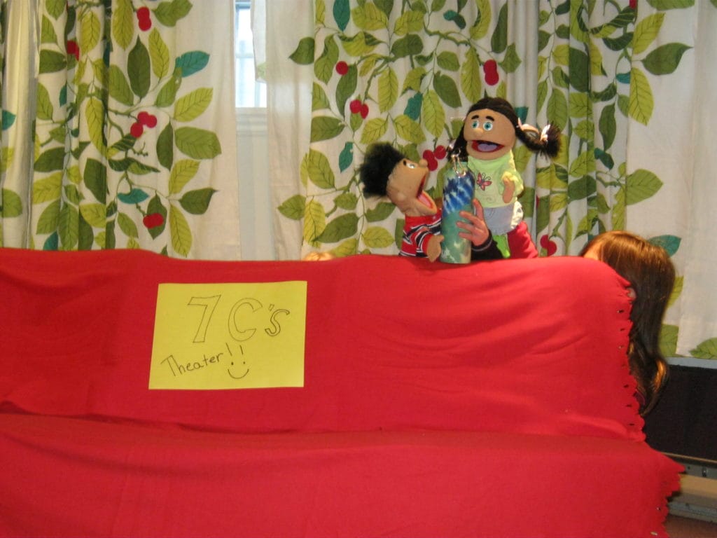 A child playing with puppets.