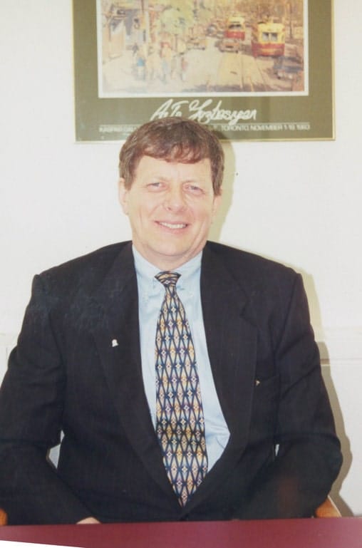 Les Talbot sitting at desk.