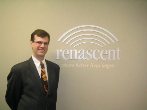 Michael Mazza standing by Renascent wall sign.