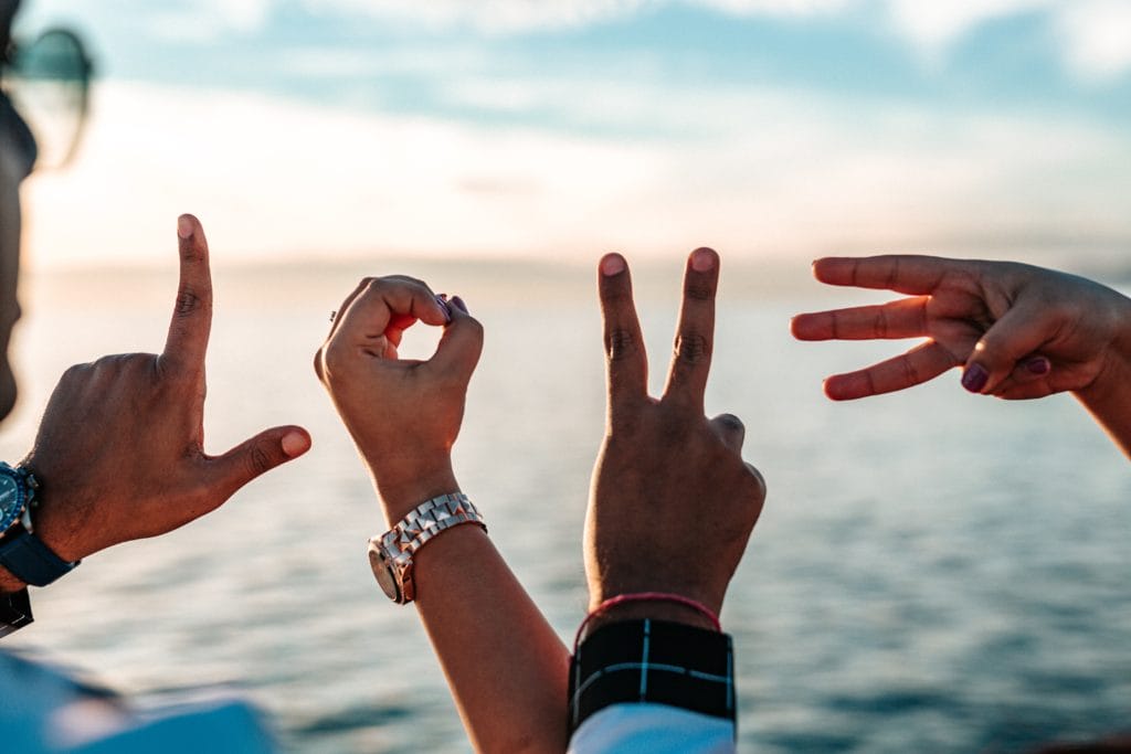 People using their hands to form the word love.