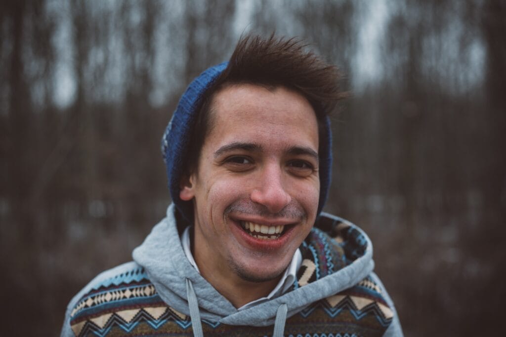 A man wearing a tuque and smiling.