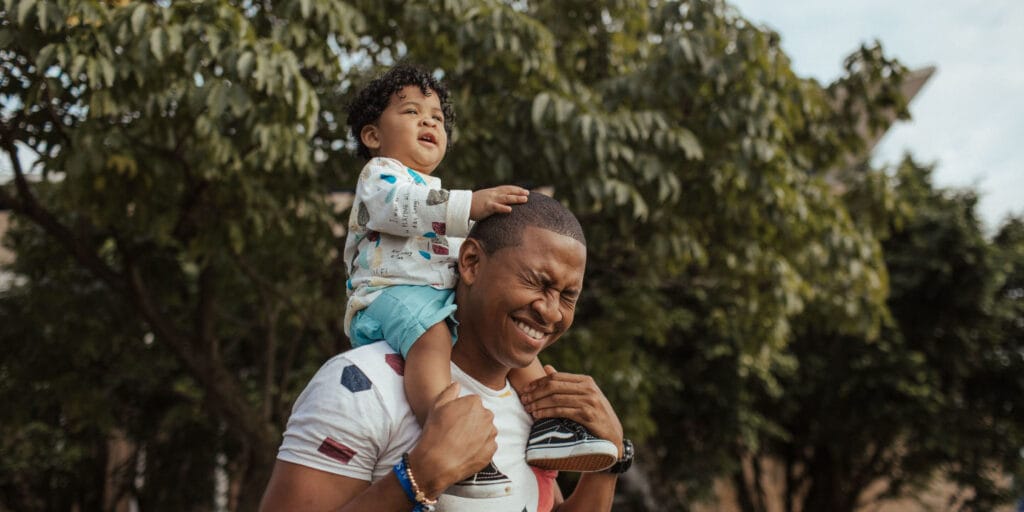 Man carrying child on shoulders.