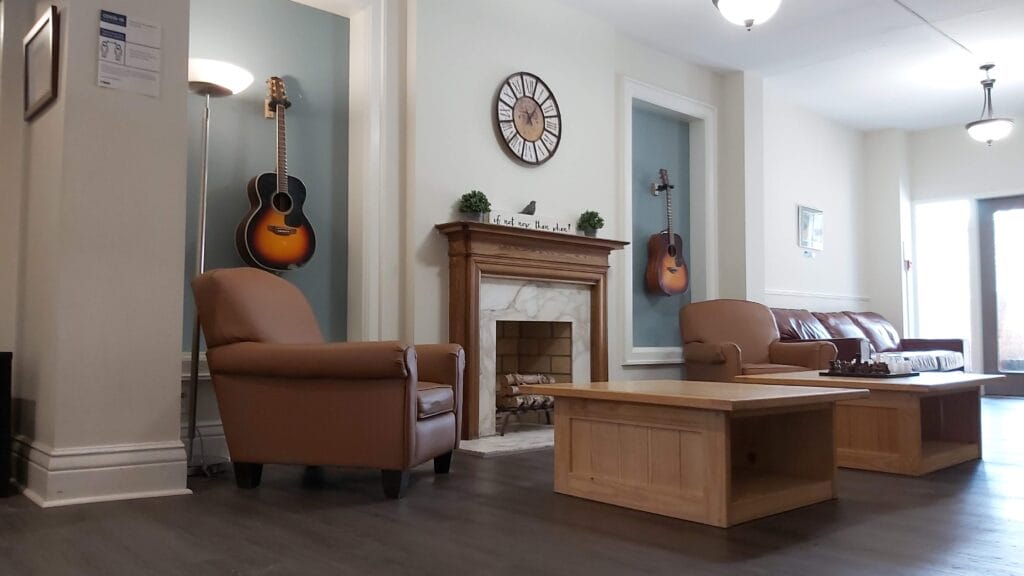 Living room with a couch, chair, tables and a fireplace.