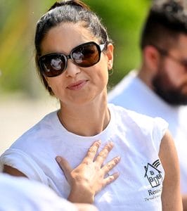 Woman in sunglasses smiling.